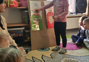 Dziecko wrzuca babeczkę do makiety babci lub dziadka.