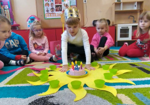 Dziecko układa koraliki na słoneczku urodzinowym.