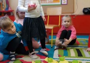 Dziecko układa koraliki na słoneczku urodzinowym.