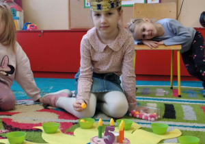 Jubilatka rozkłada koraliki na słoneczku urodzinowym.