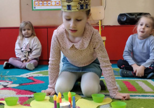 Jubilatka rozkłada koraliki na słoneczku urodzinowym.