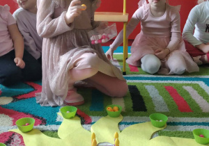 Jubilatka rozkłada koraliki na słoneczku urodzinowym.