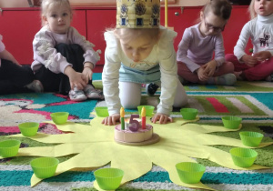 Jubilatka rozkłada koraliki na słoneczku urodzinowym.