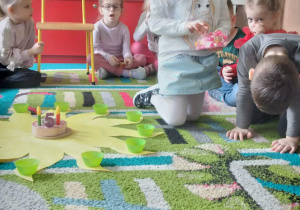 Jubilatka rozkłada koraliki na słoneczku urodzinowym.