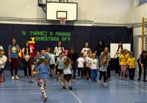 Dzieci na sali gimnastycznej biorą udział w turnieju.