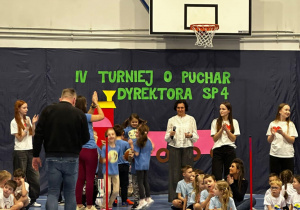 Dzieci na sali gimnastycznej biorą udział w turnieju.