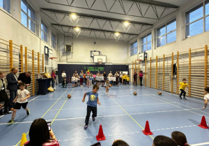 Dzieci na sali gimnastycznej biorą udział w turnieju.