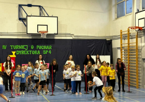 Dzieci na sali gimnastycznej biorą udział w turnieju.