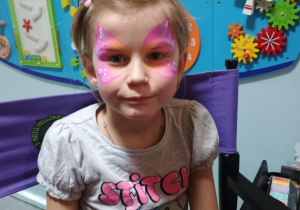 Dziecko z malunkiem na twarzy.