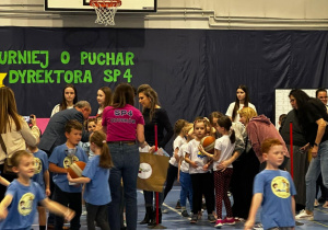 Dzieci na sali gimnastycznej biorą udział w turnieju.