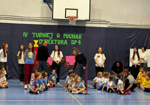Dzieci na sali gimnastycznej biorą udział w turnieju.