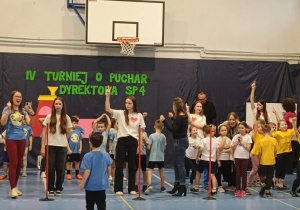 Dzieci na sali gimnastycznej biorą udział w turnieju.