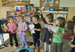 Dzieci trzymają elementy pogodowe.