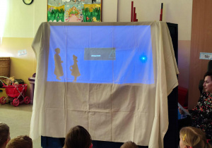 Dzieci oglądają przedszkolny teatr cieni.