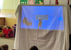 Dzieci oglądają przedszkolny teatr cieni.