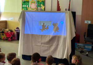 Dzieci oglądają przedszkolny teatr cieni.