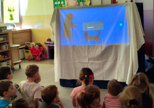 Dzieci oglądają przedszkolny teatr cieni.