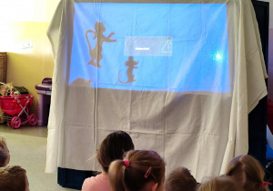 Dzieci oglądają przedszkolny teatr cieni.