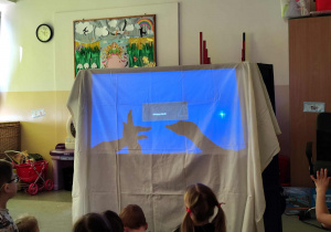 Dzieci oglądają przedszkolny teatr cieni.