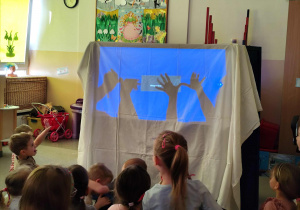 Dzieci oglądają przedszkolny teatr cieni.