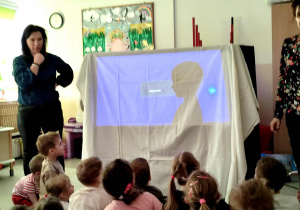 Dzieci oglądają przedszkolny teatr cieni.