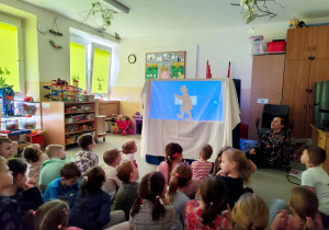 Dzieci oglądają przedszkolny teatr cieni.