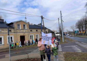 Wiosenny przemarsz dzieci ulicami miasta.