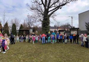 Dzieci świętują nadejście wiosny koło przedszkola.