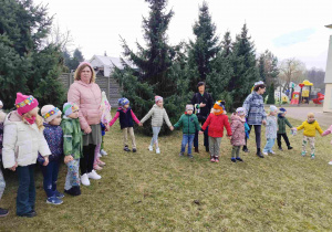 Dzieci świętują nadejście wiosny koło przedszkola.
