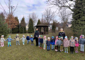 Dzieci świętują nadejście wiosny koło przedszkola.