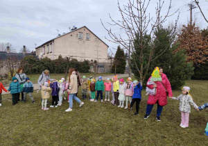Dzieci świętują nadejście wiosny koło przedszkola.