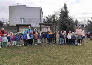 Dzieci świętują nadejście wiosny koło przedszkola.