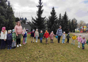Dzieci świętują nadejście wiosny koło przedszkola.