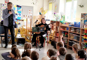 Dzieci słuchają gitarowego koncertu.