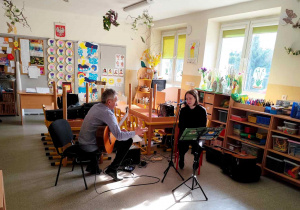 Dzieci słuchają gitarowego koncertu.