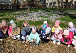 Dzieci w parku wśród kwiatów.