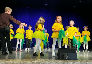 Dzieci w żółtych koszulkach na scenie podczas występu w MOKu.
