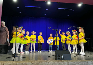 Dzieci w żółtych koszulkach na scenie podczas występu w MOKu.