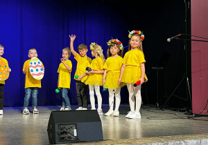 Dzieci w żółtych koszulkach na scenie podczas występu w MOKu.