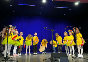 Dzieci w żółtych koszulkach na scenie podczas występu w MOKu.