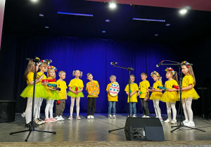 Dzieci w żółtych koszulkach na scenie podczas występu w MOKu.