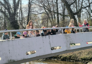 Dzieci na moście rzucają Marzanne do wody.