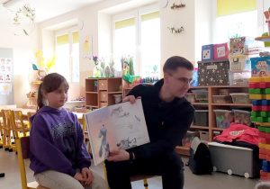 Tata dziewczynki czyta dzieciom bajkę.