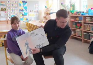 Tata dziewczynki czyta dzieciom bajkę.