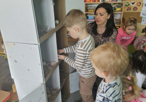 Dzieci przeliczają jajka w kurniku.