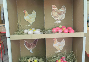 Dzieci przeliczają jajka w kurniku.