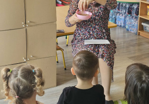 Dzieci przeliczają jajka w kurniku.