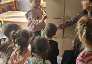 Dzieci przeliczają jajka w kurniku.