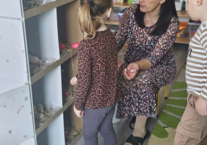 Dzieci przeliczają jajka w kurniku.