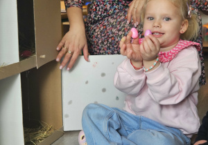 Dzieci przeliczają jajka w kurniku.